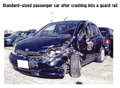 Standard-sized passenger car after crashing into a guard rail